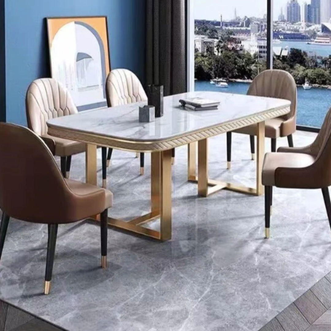 The Luxury Black Marble Dining Table Set is a masterpiece of modern elegance and timeless design. It features a premium black marble tabletop that exudes luxury, beautifully supported by a rectangular stainless steel base in a gold finish that adds a glamorous touch. The contrast of dark marble with gleaming gold metal creates a dramatic yet refined look — ideal for upscale interiors. This dining set is crafted not just for beauty but also for durability, making it perfect for both everyday dining and special occasions. The table is available with matching upholstered or leatherette chairs, and customization options are offered for marble tone, frame finish, and chair style, allowing you to personalize it to suit your space perfectly. 1